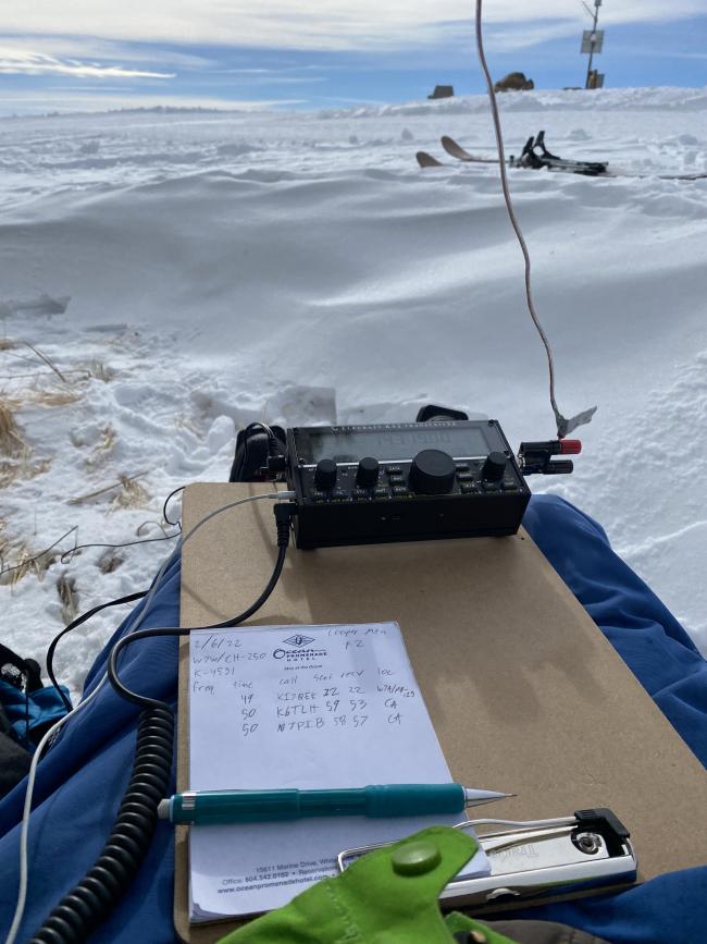 A KX2 with a wire antenna sitting on a clipboard on my lap