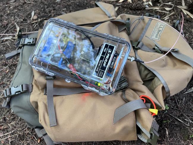 A radio box sits on a backpack