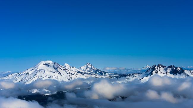 South Sister, Middle Sister, North Sister, and Broken Top Mountains in blue ski